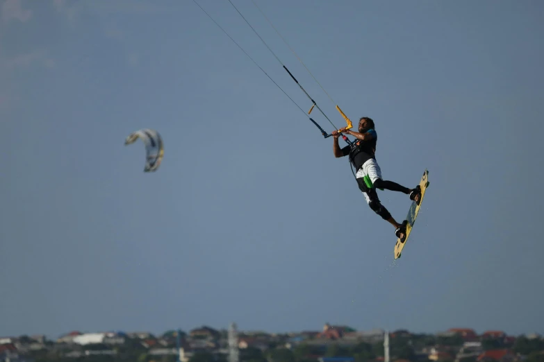 a man standing on one leg and holding on to rope attached to water skis