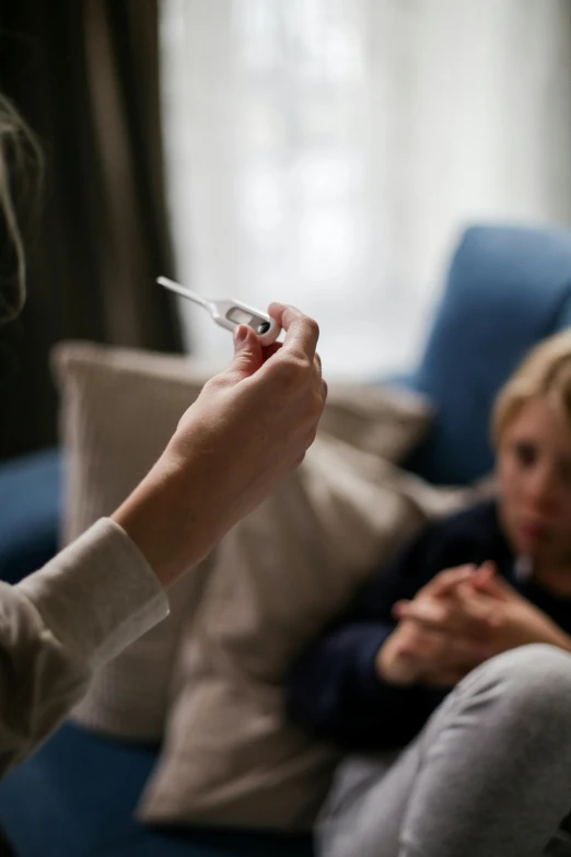 a person sitting on a couch holding a cigarette