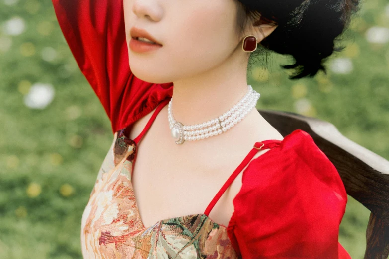 woman in a red dress and pearl necklace