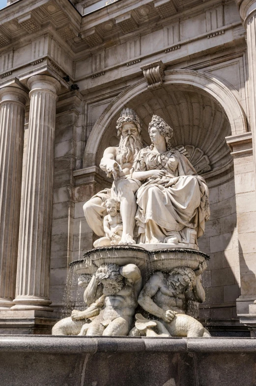 a statue on the top of a stone fountain