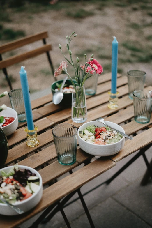 a table with plates, glasses and cups and flowers on it