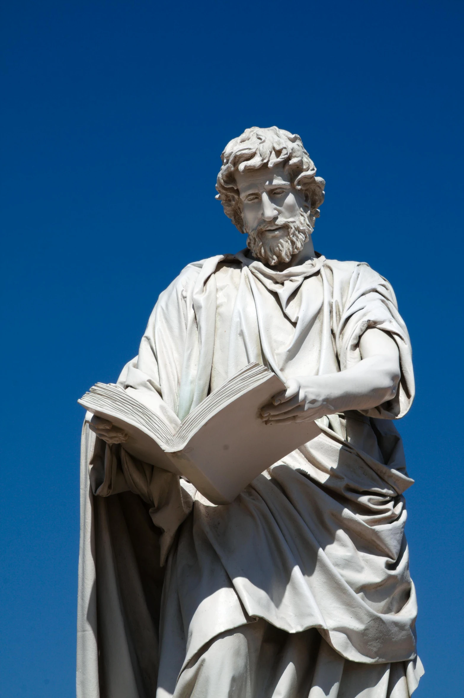 an old white statue with a blue sky in the background