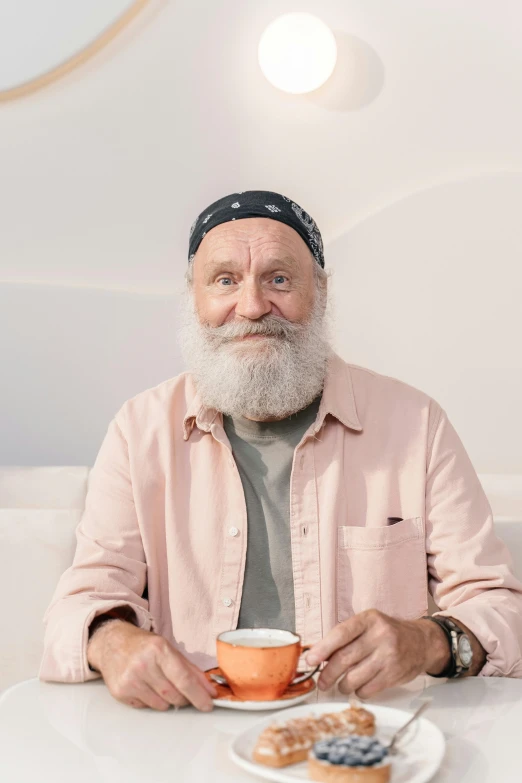a man sitting at a table with a cup of coffee