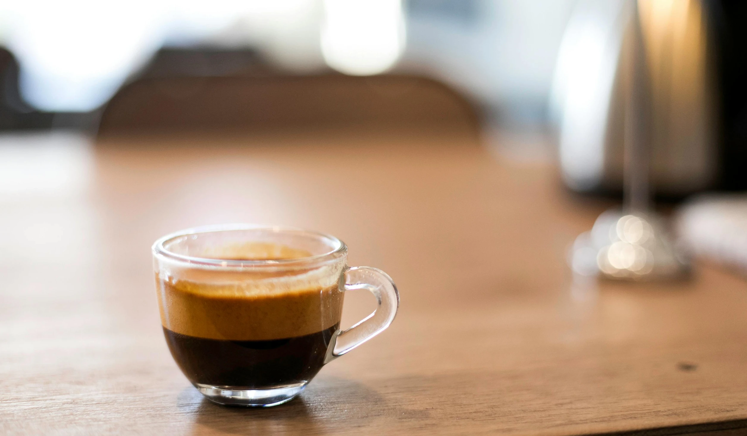 a brown liquid in a glass cup sitting on a table