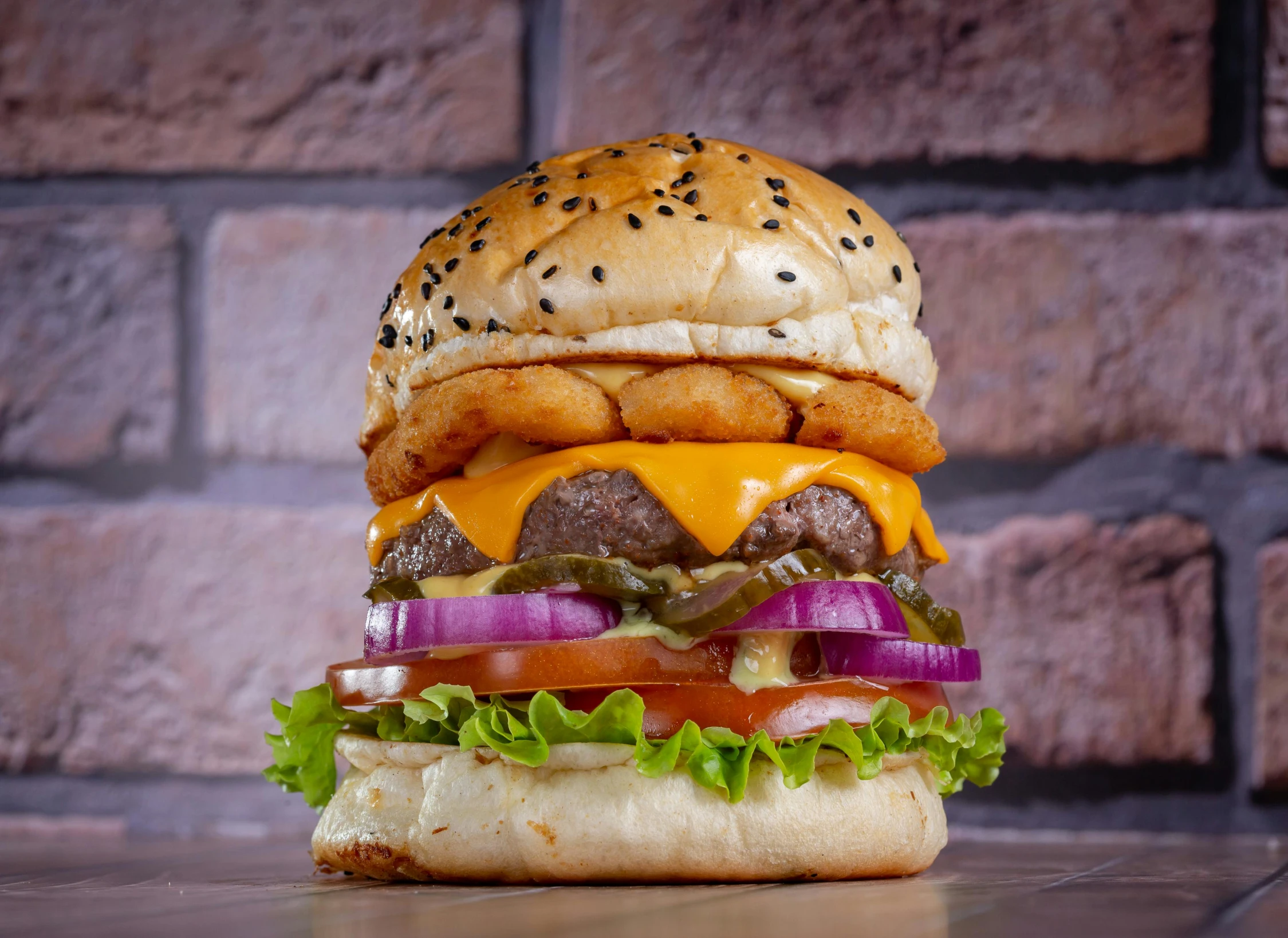 a cheeseburger with onion and tomato is on a table