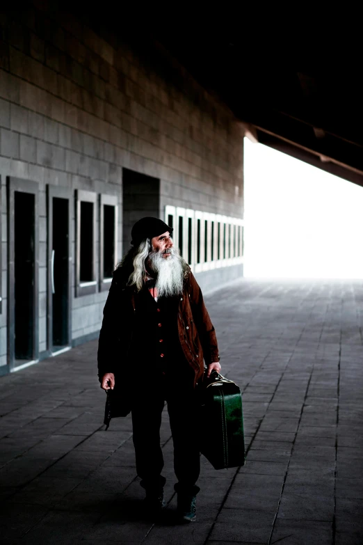 a man in a long beard with a suit case