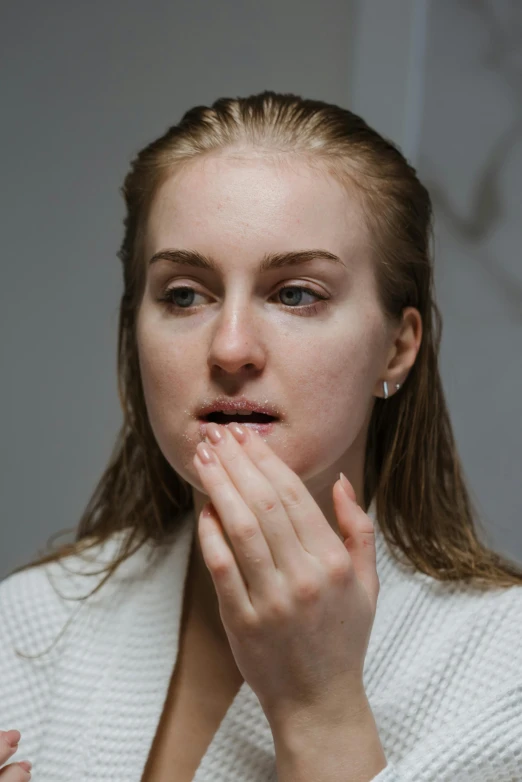 a young woman with a white sweater covers her face