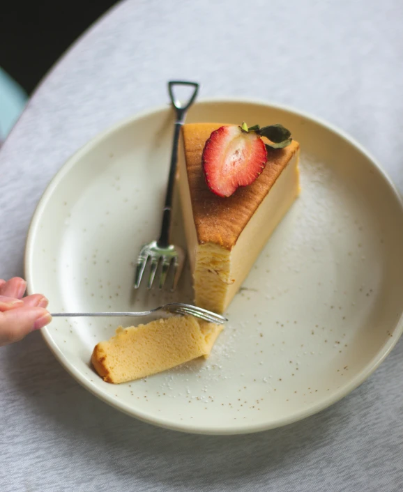 a hand holding a fork and knife about to eat a piece of pie