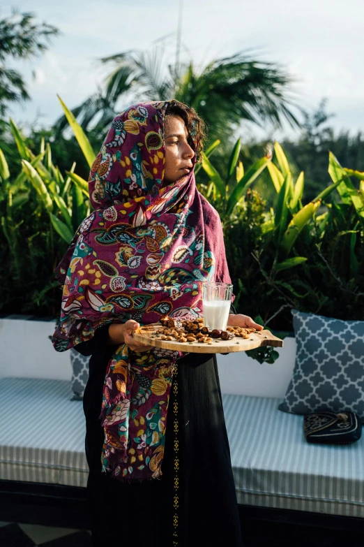 a woman carrying a plate full of cookies and milk