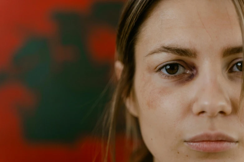 the eyes of a woman in front of an artisticly colored background