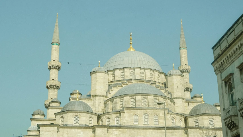 a large white building with three spires against a blue sky