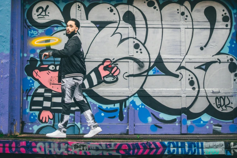 man walking in front of graffiti with frisbee