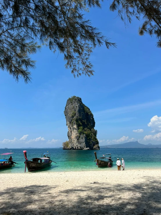 several boats sitting on the shore in front of the ocean