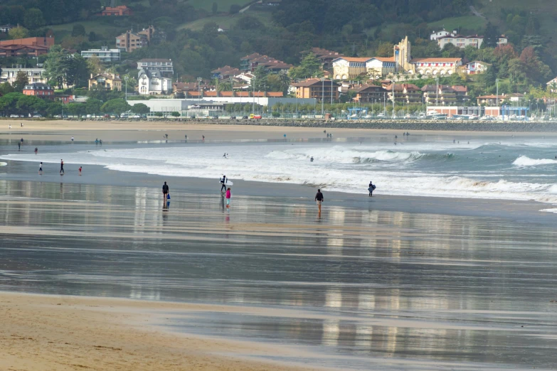 a couple of people are walking in the water on a beach