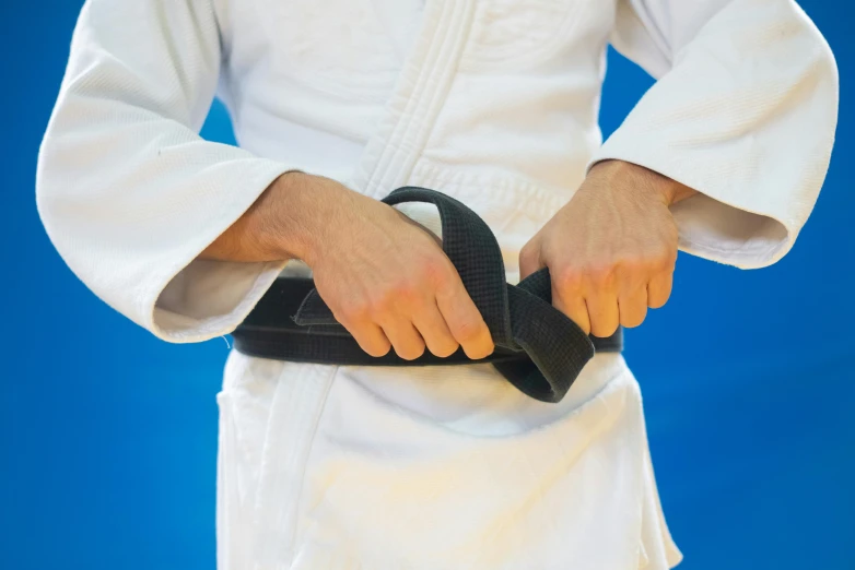 a person is wearing a black belt and white pants