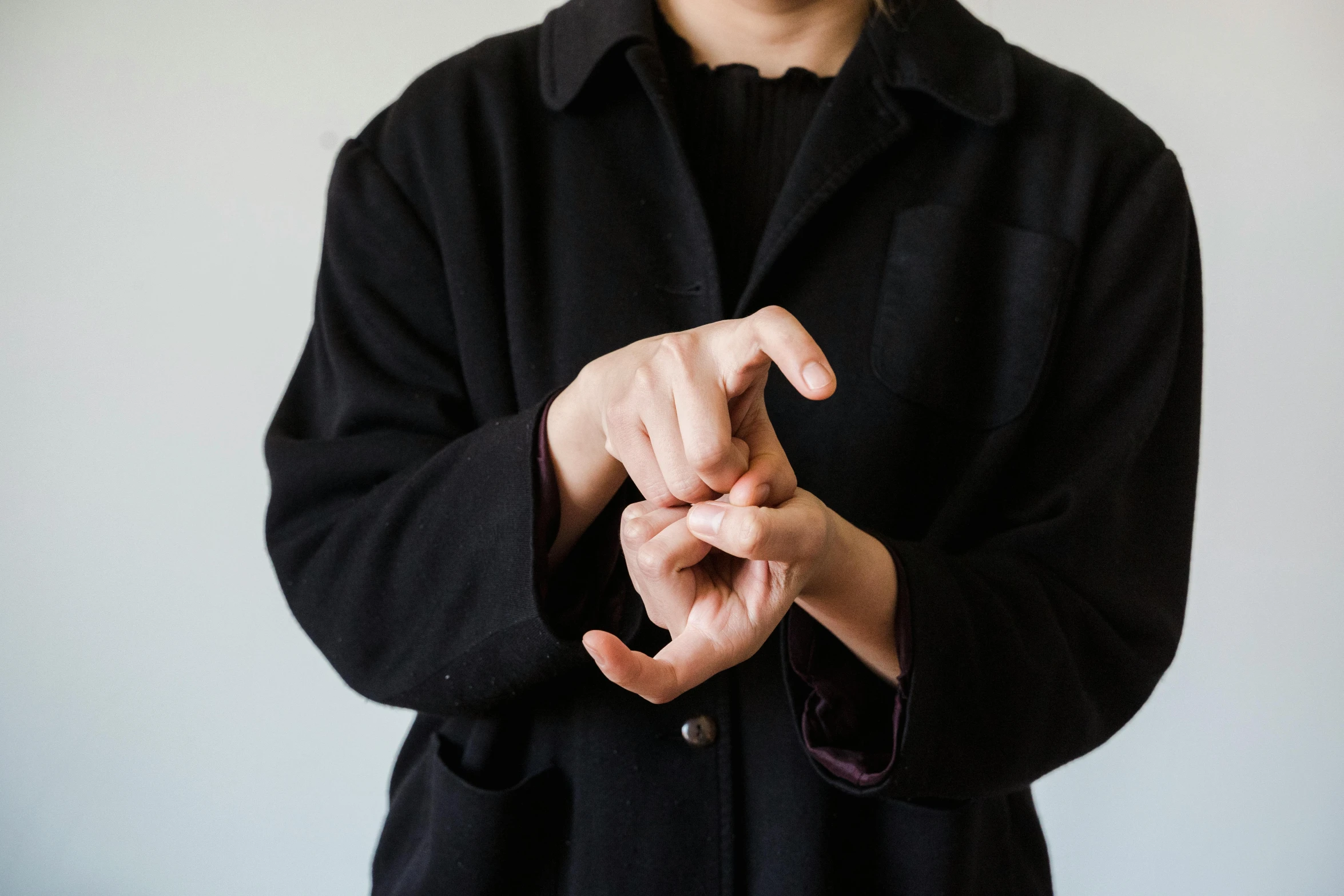 a young man in black jacket and hat pointing at soing