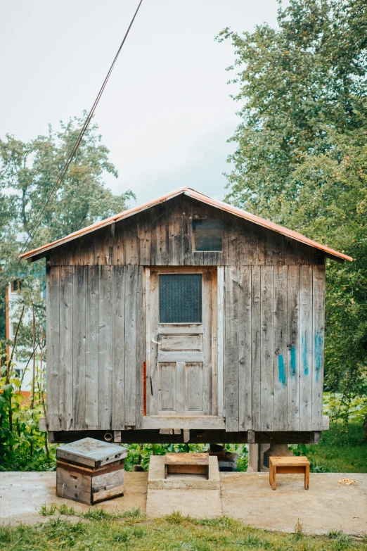 the small shack is sitting outside in the grass