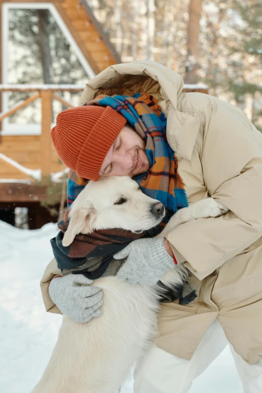 a man is hugging a dog in the snow