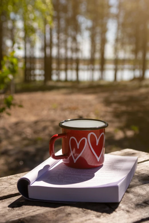 a red mug sitting on top of a paper on a table