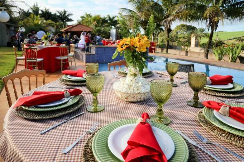 a table set with place settings and place settings near a pool