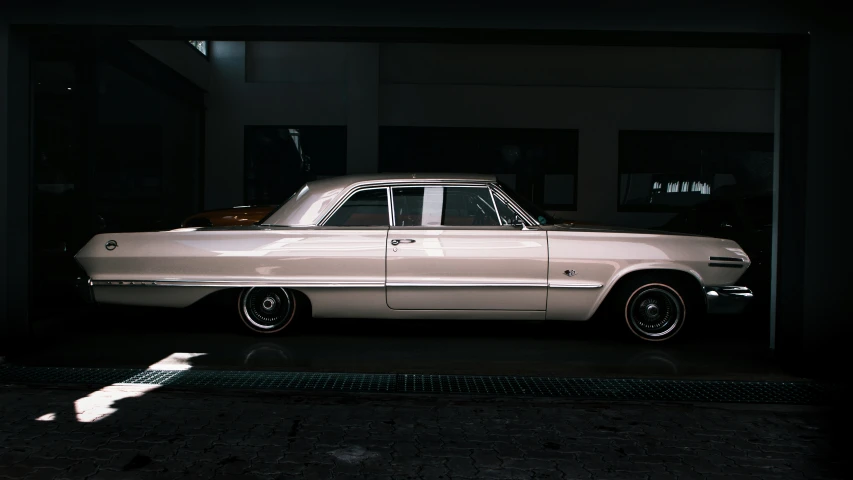 an old car in a garage, with it's top window open