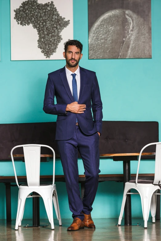 the man in a blue suit stands in front of white chairs