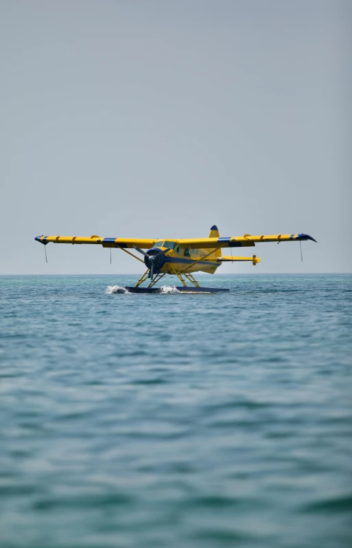 a water plane flying over the ocean near land