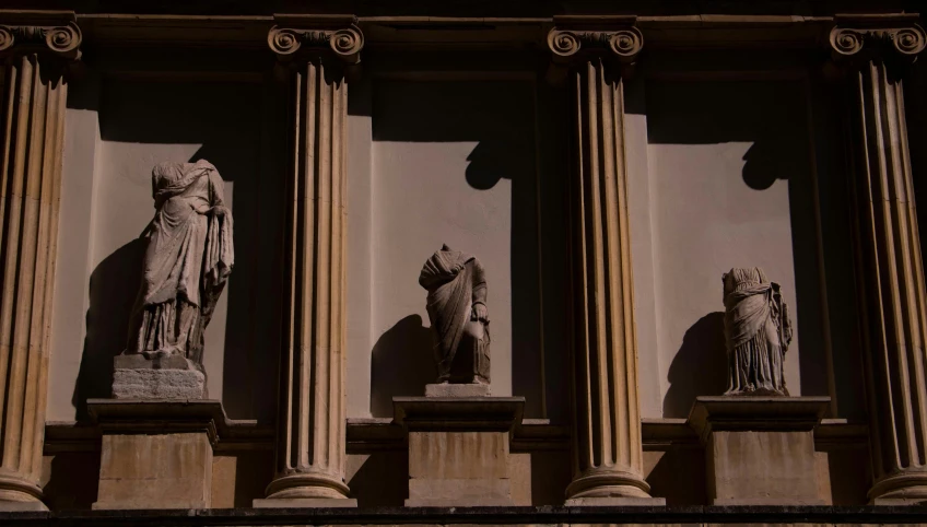 some stone statues sitting on top of a building