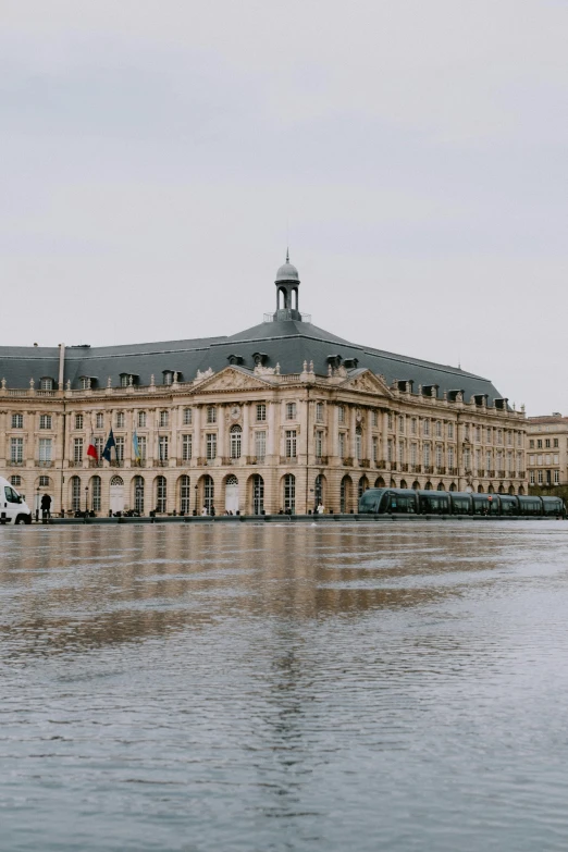 the water is reflecting the building in front of it