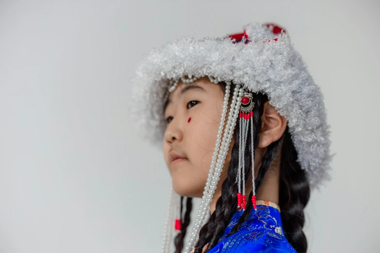 a  with long hair is wearing a hat with feathers and beads