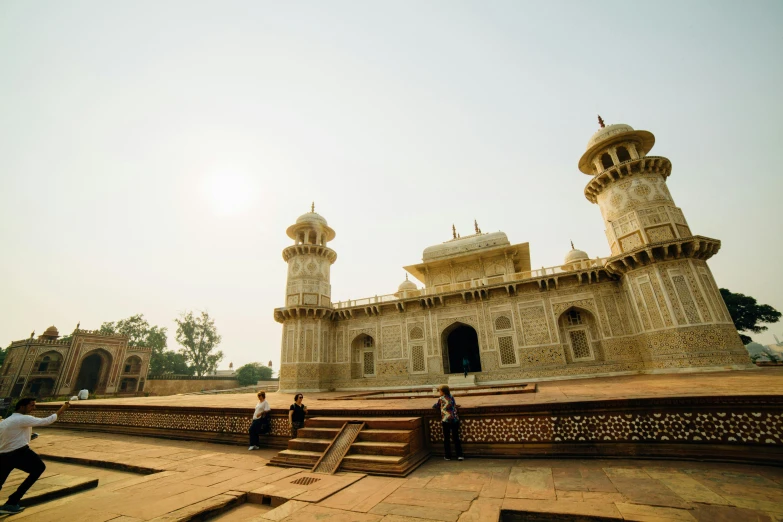 the people are walking near the old building