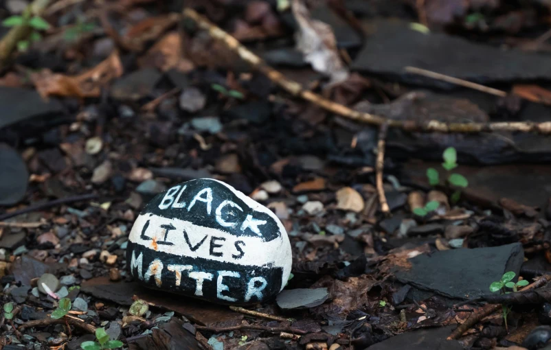 black lives matter written on a rock on the ground