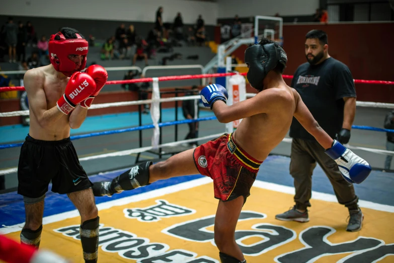 two boxers wearing red trunks and black shorts are facing each other