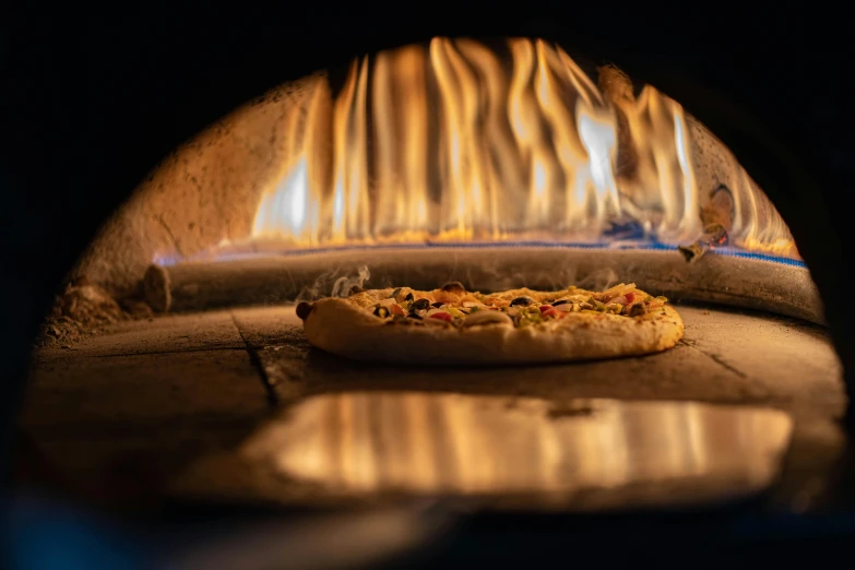 a pizza sits on the outside of an oven