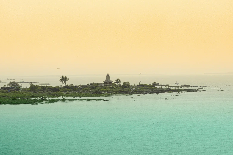 a small island in the middle of the ocean with some tall buildings