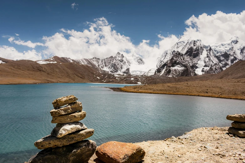 rocks and some water in front of a mountain