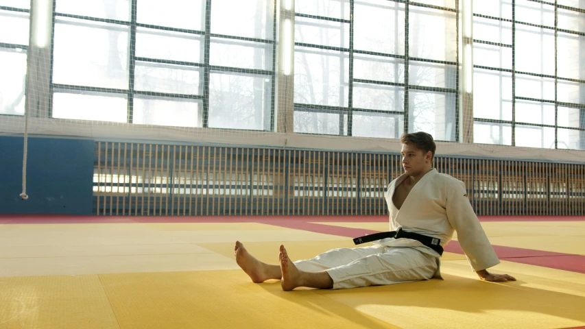 a man sitting on a mat talking on a cell phone