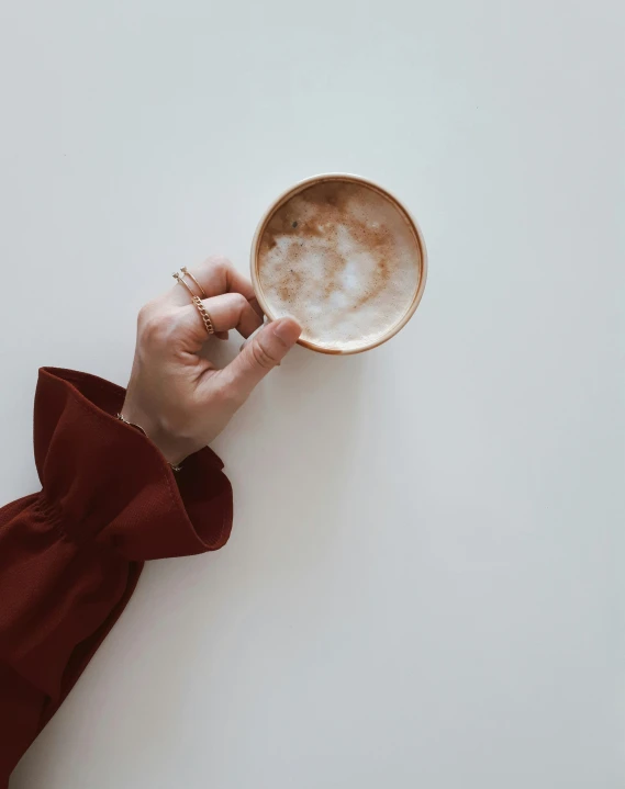 a person holding a cup on a table