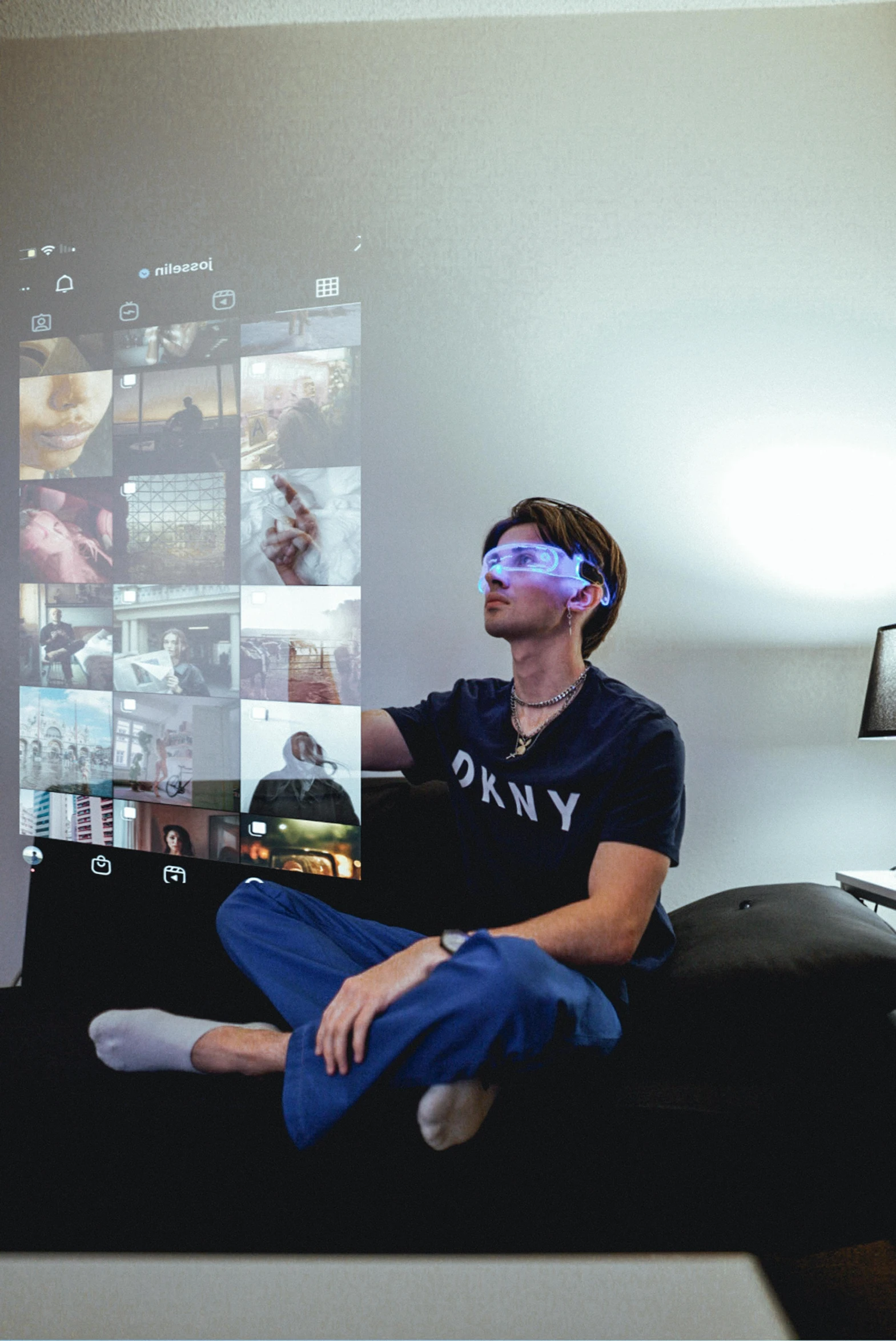 a young man sitting on top of a black couch