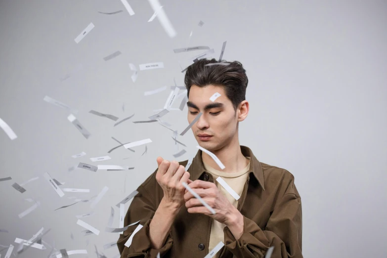 a man holding a glass with a lot of shredded papers next to him