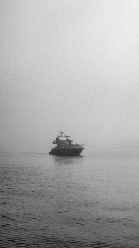 boat in the fog and light over water