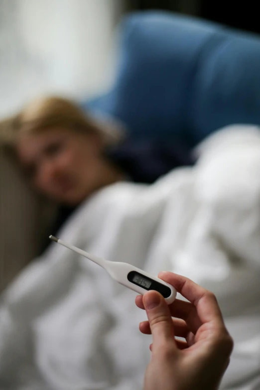 a girl is holding a thermometer in her hand