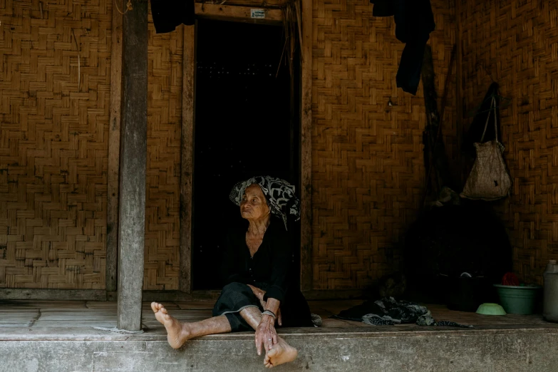 a woman in a black top sitting outside of a house