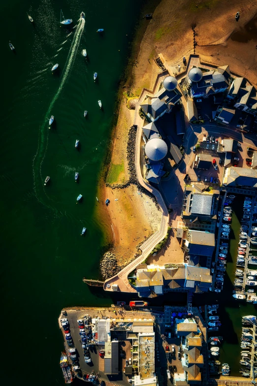 an aerial po of the sea with boats at dock and houses on land