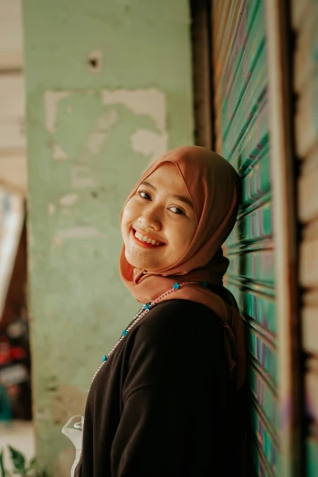 an image of a young woman with hijab smiling