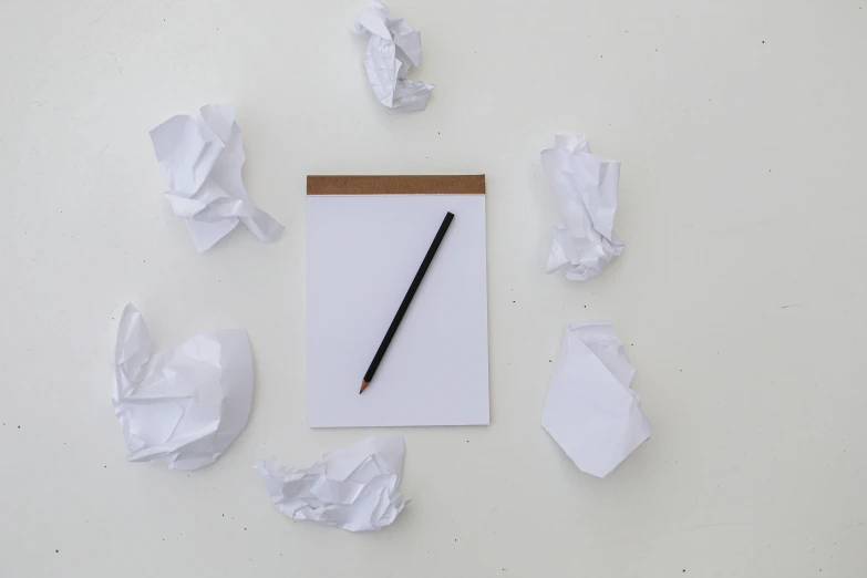 a note pad with a pen sitting on top of torn paper