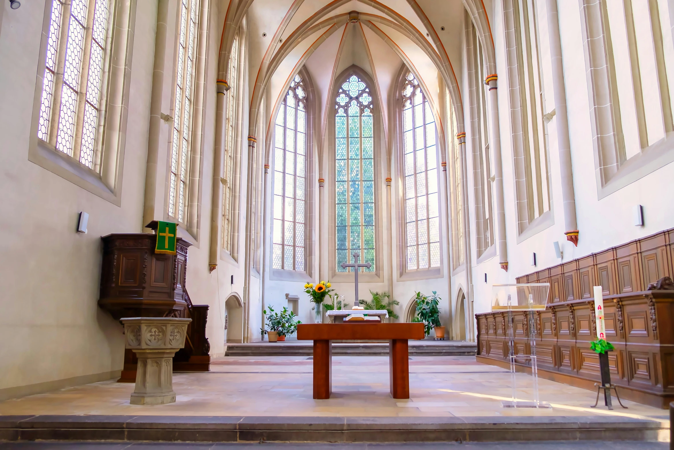 a room full of empty pews with a stained glass window