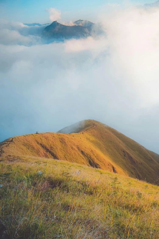 some tall mountains and clouds and grass