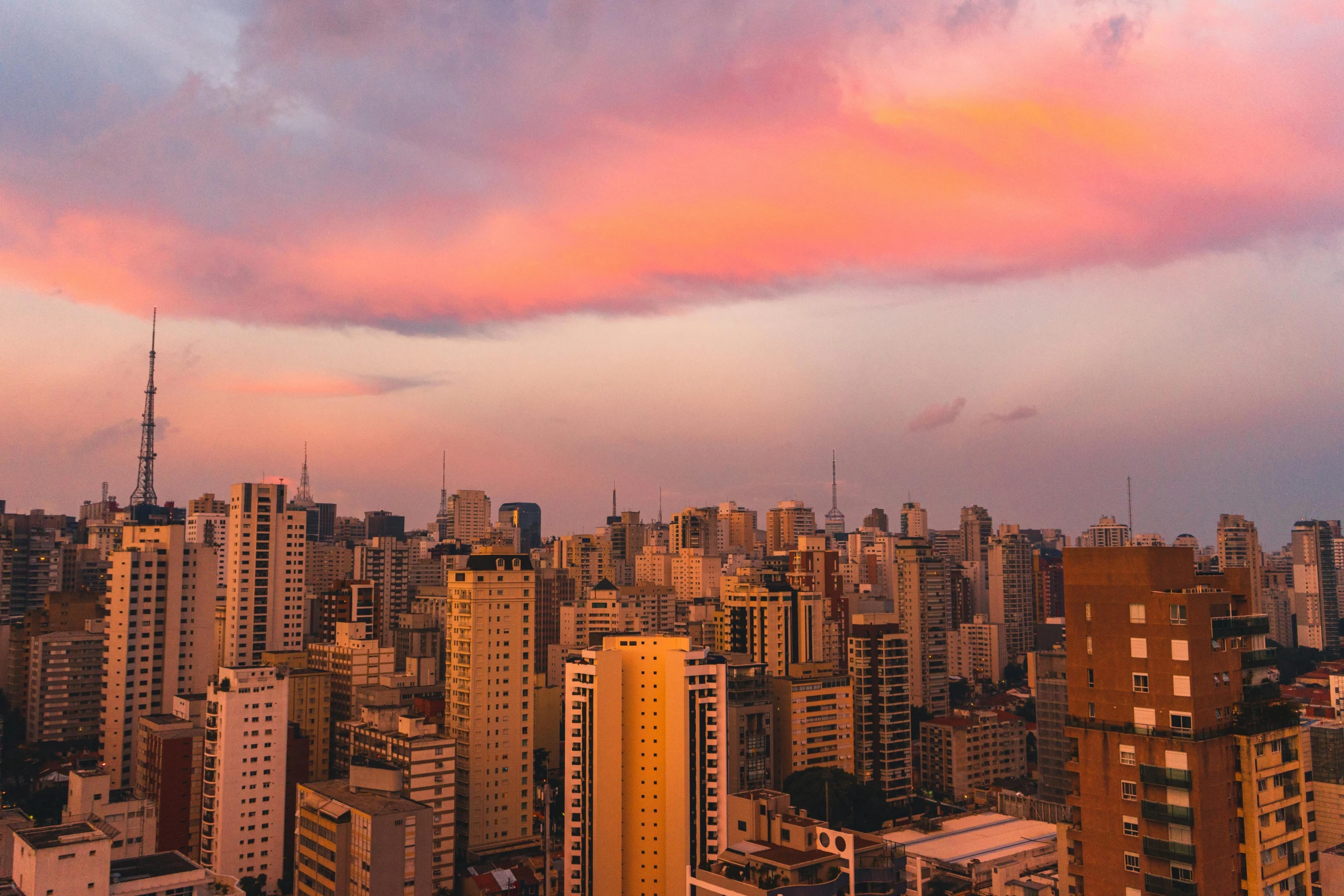 an overview of many different city buildings with a pink sky