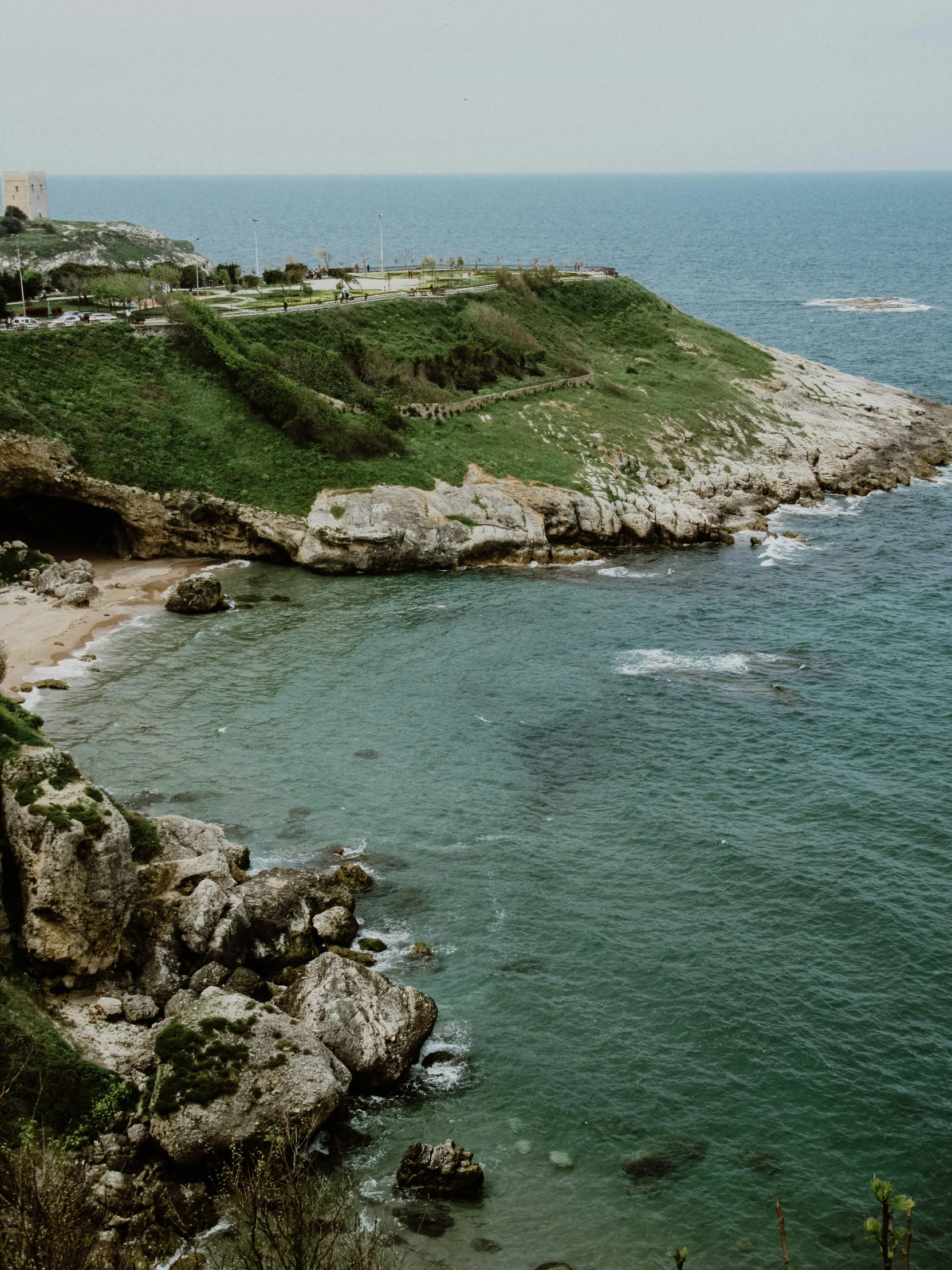 a rocky beach near the ocean with a few people